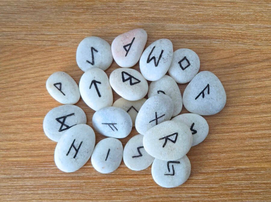 Rünlerin anlamları — daire içinde dizilmiş parlayan 24 Elder Futhark sembolü